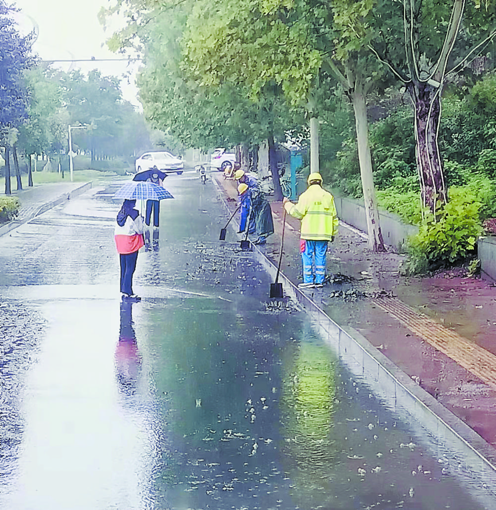 环卫工全员出击冒雨清淤保畅通